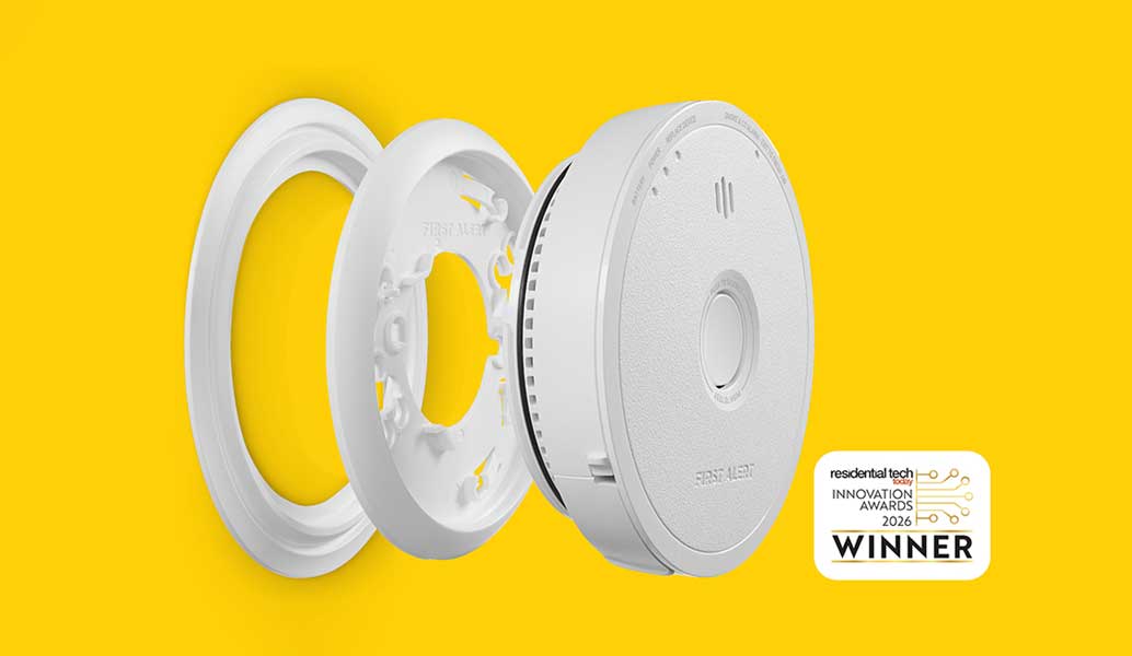 Parts of a smoke alarm shown separated, including the mounting ring and the alarm with new award-winning line.