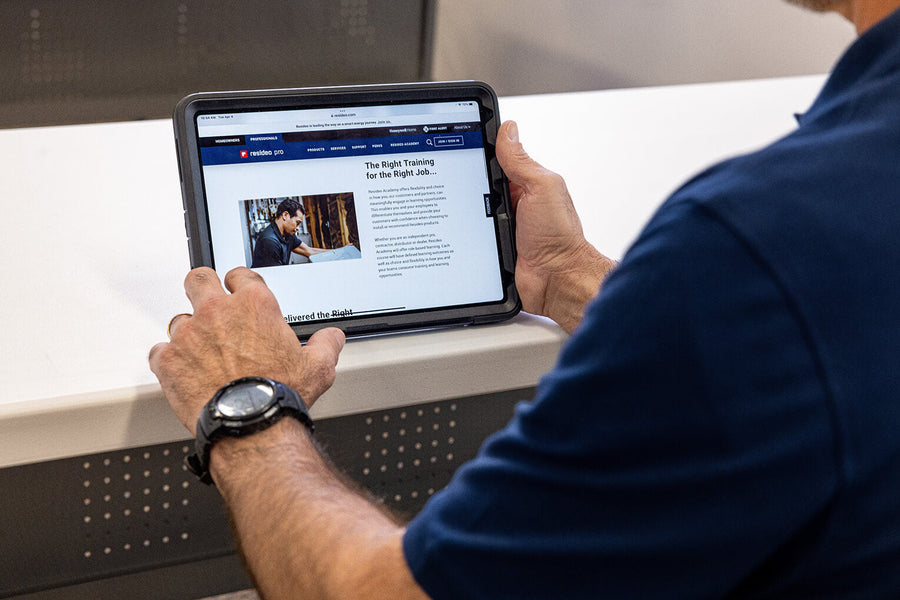 A technician is watching the Resideo Academy page on an ipad.