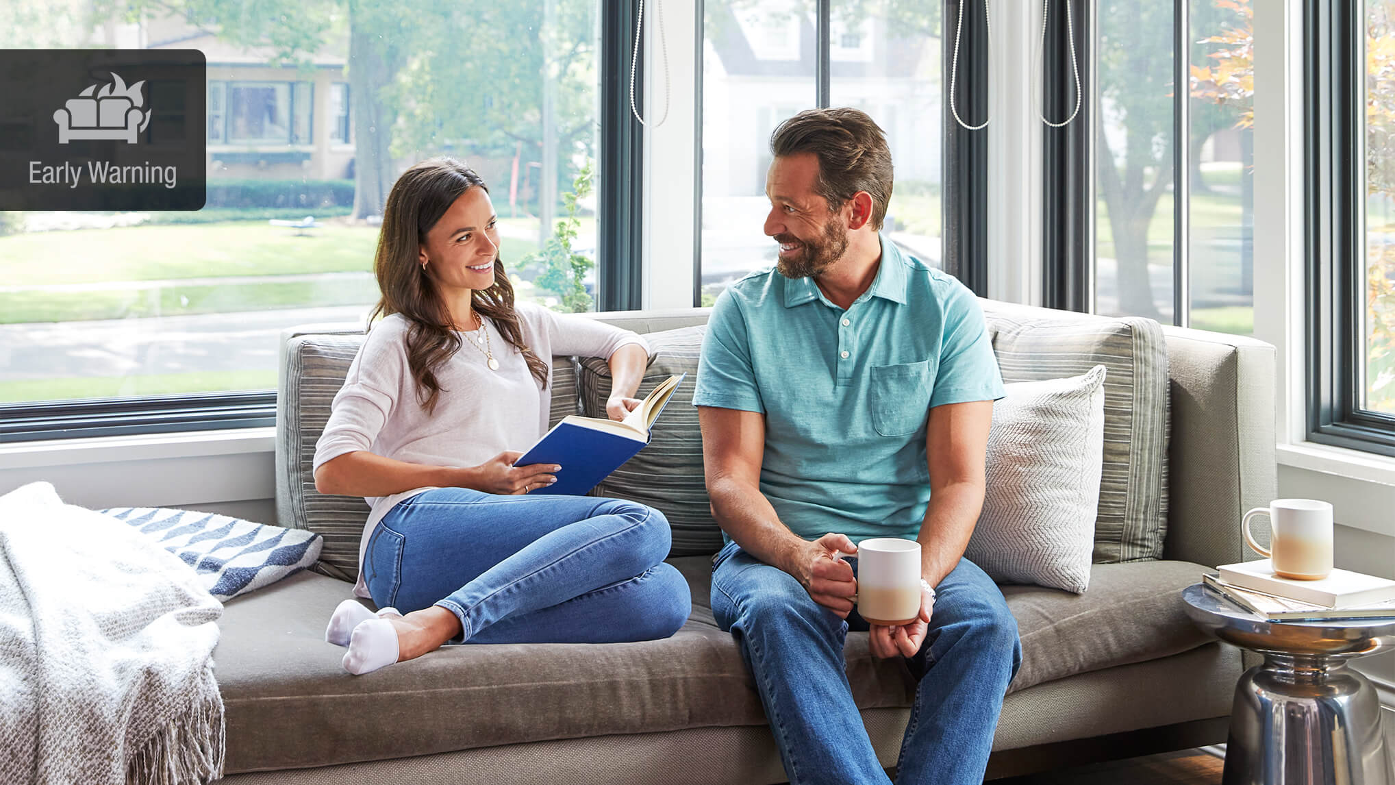 Couple sitting on the couch by a window 